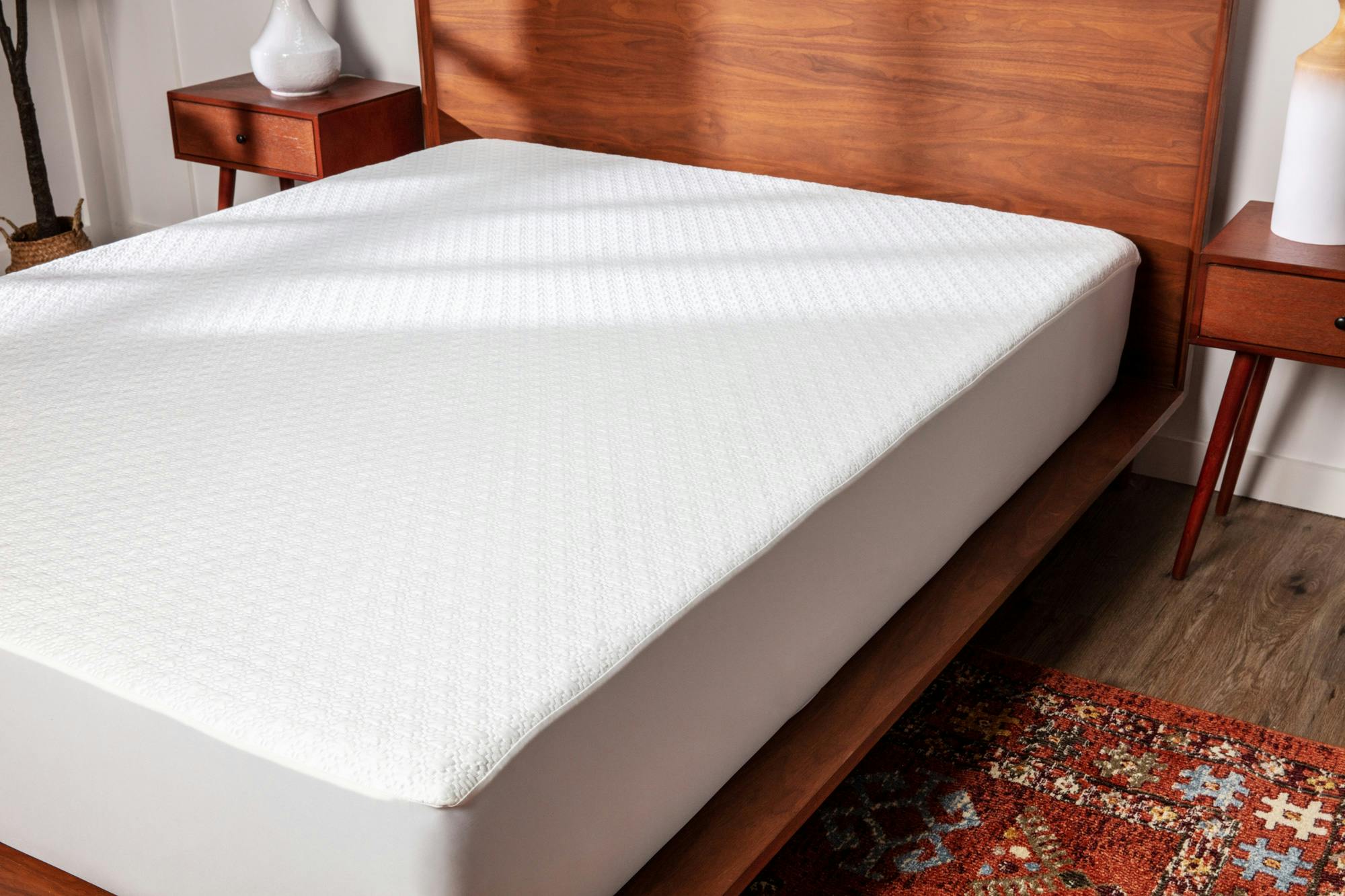 A white cooling mattress protector fitted to a bed