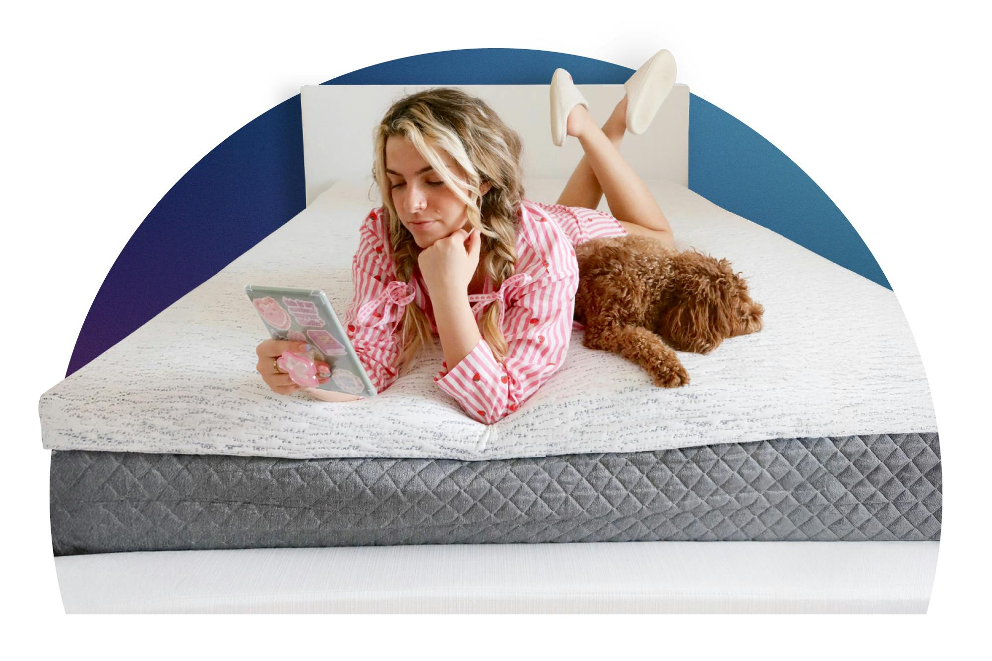 Young woman reading on dorm bed with dog, on white memory foam mattress topper.