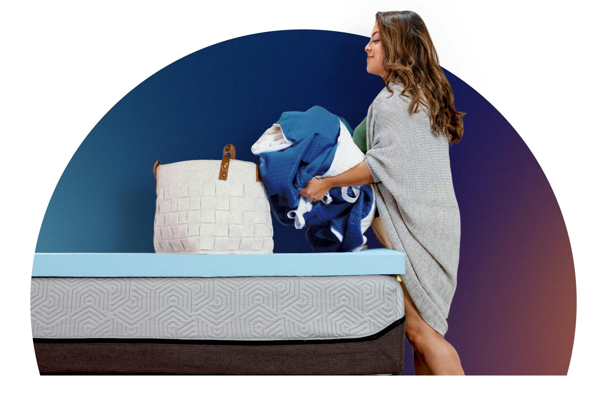 Woman placing mattress topper cover in laundry basket on a bed with a blue mattress topper.