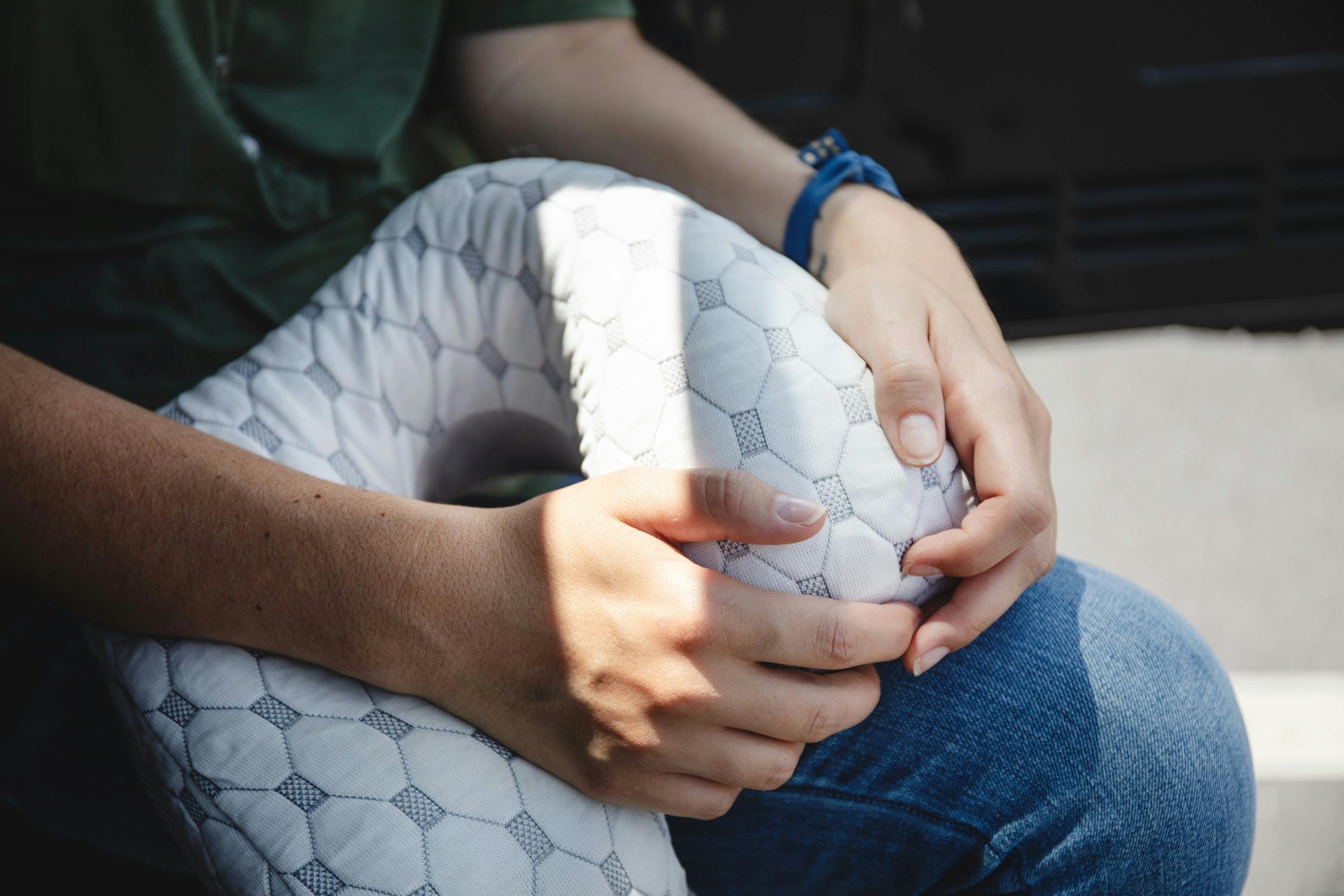 Photo of a woman holding a viscosoft neck pillow on her lap