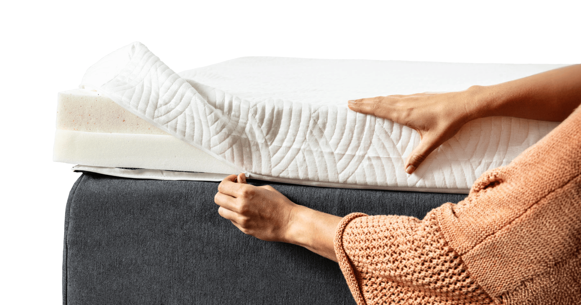 a person unzipping a white mattress topper cover to show that you can remove it to throw in the wash