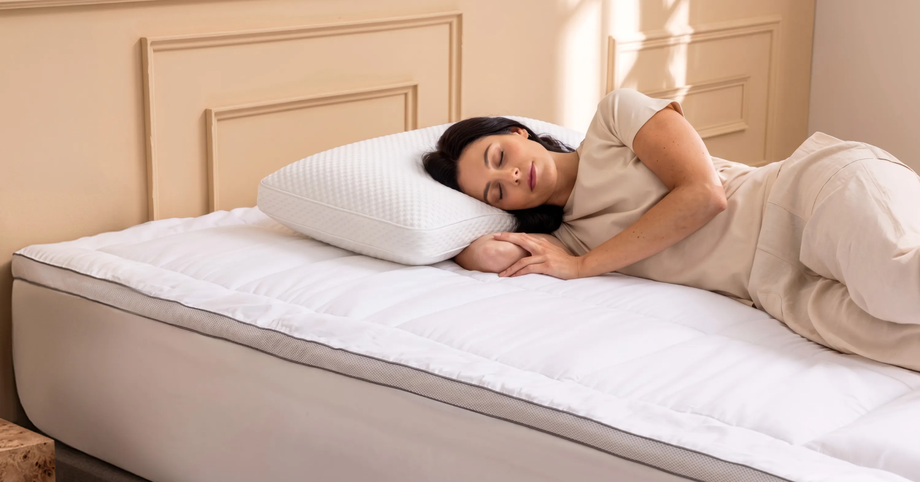A woman sleeping on a plush pillow top mattress topper with a thick memory foam pillow under her head