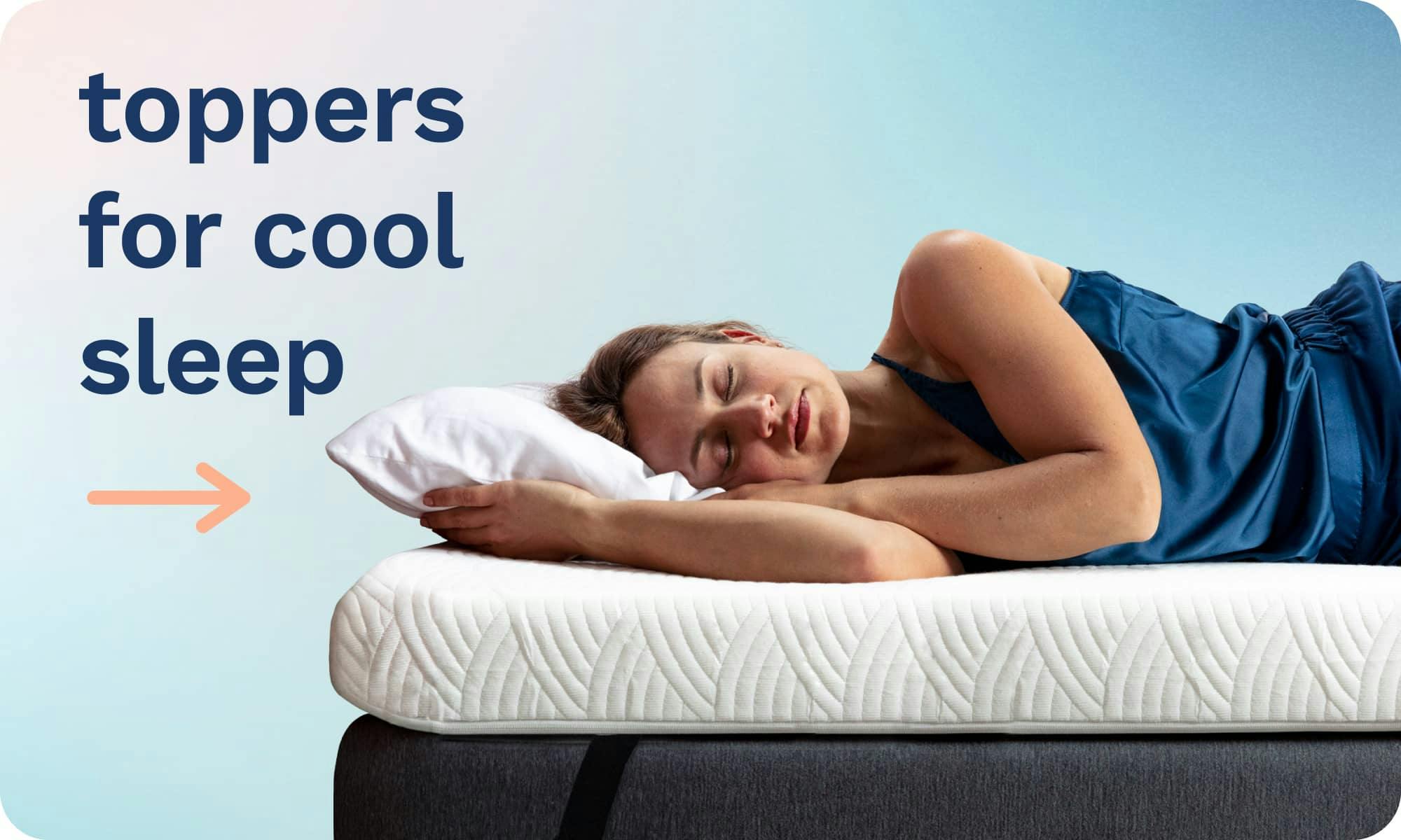 Toppers for sleeping cool; A woman asleep on her side on a thick white mattress topper attached to a bed with a black elastic strap.