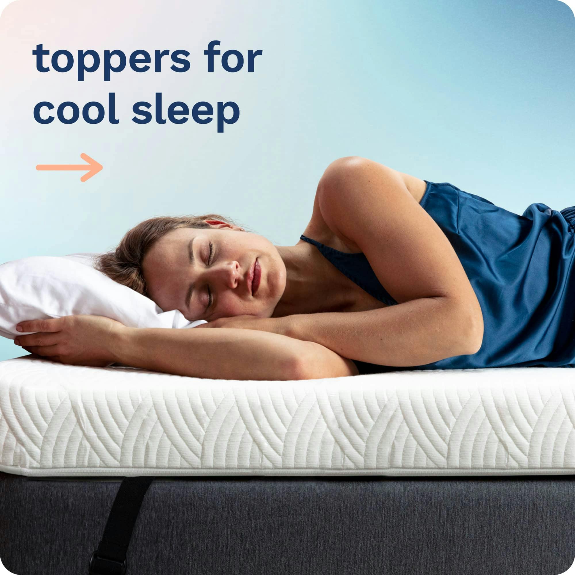 Toppers for sleeping cool; A woman asleep on her side on a thick white mattress topper attached to a bed with a black elastic strap.