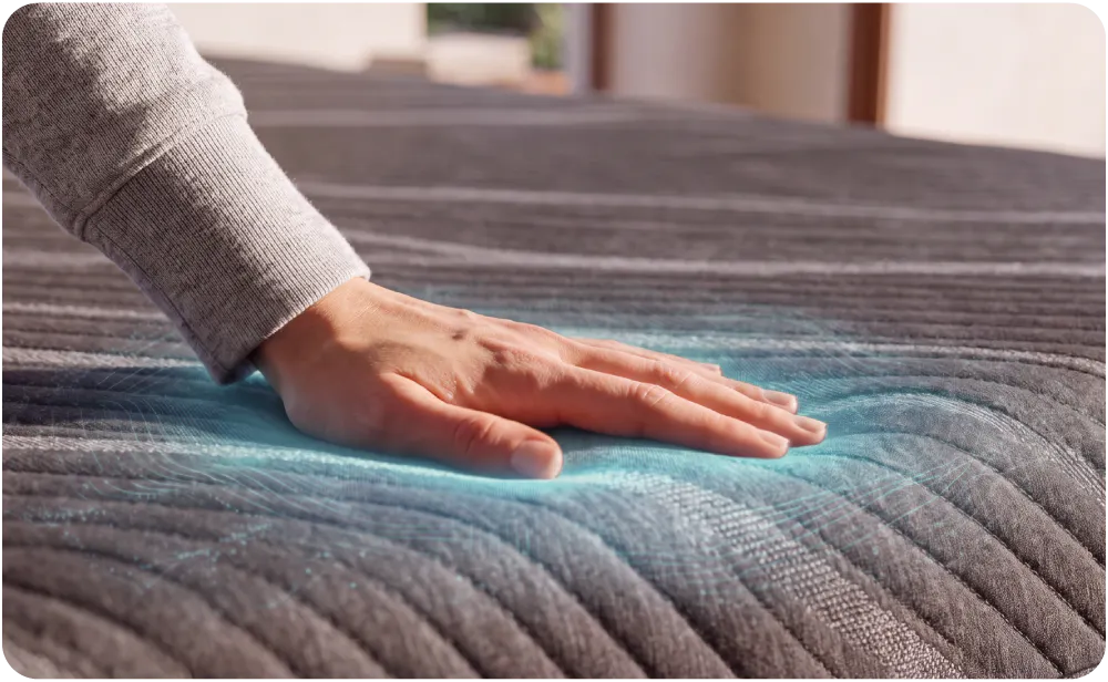 A woman lounging and leaning back on her elbows on a mattress. Ever point where her body touches the mattress, shows a cooling overlay effect, visualizing the cool, breathability of the mattress.