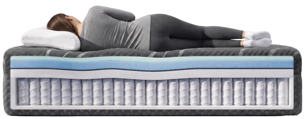 A woman sleeping on a black mattress that is showing the internal construction consisting of a plush comfort layer with a hybrid foundation