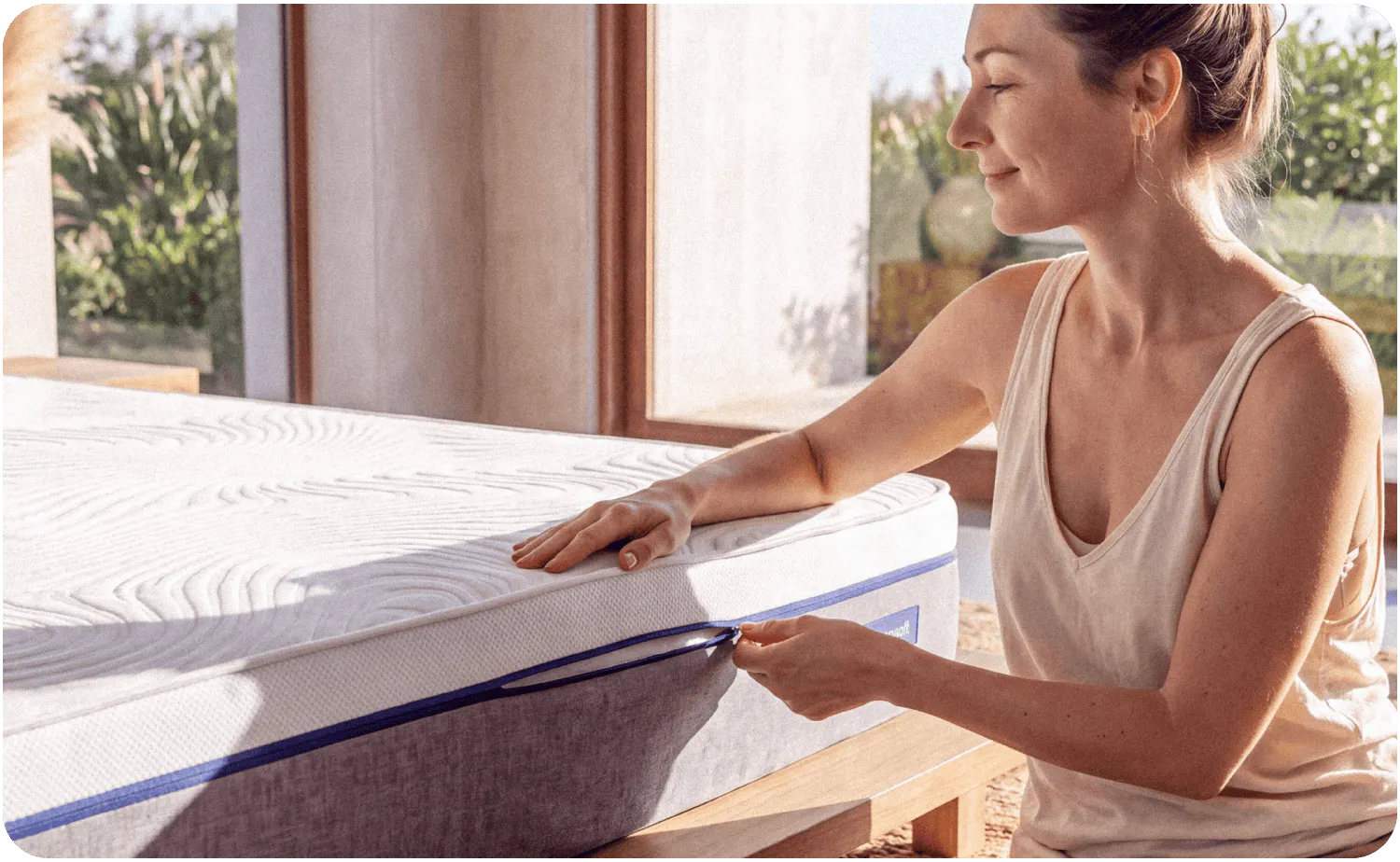 A woman unzipping a removable, machine washable mattress cover