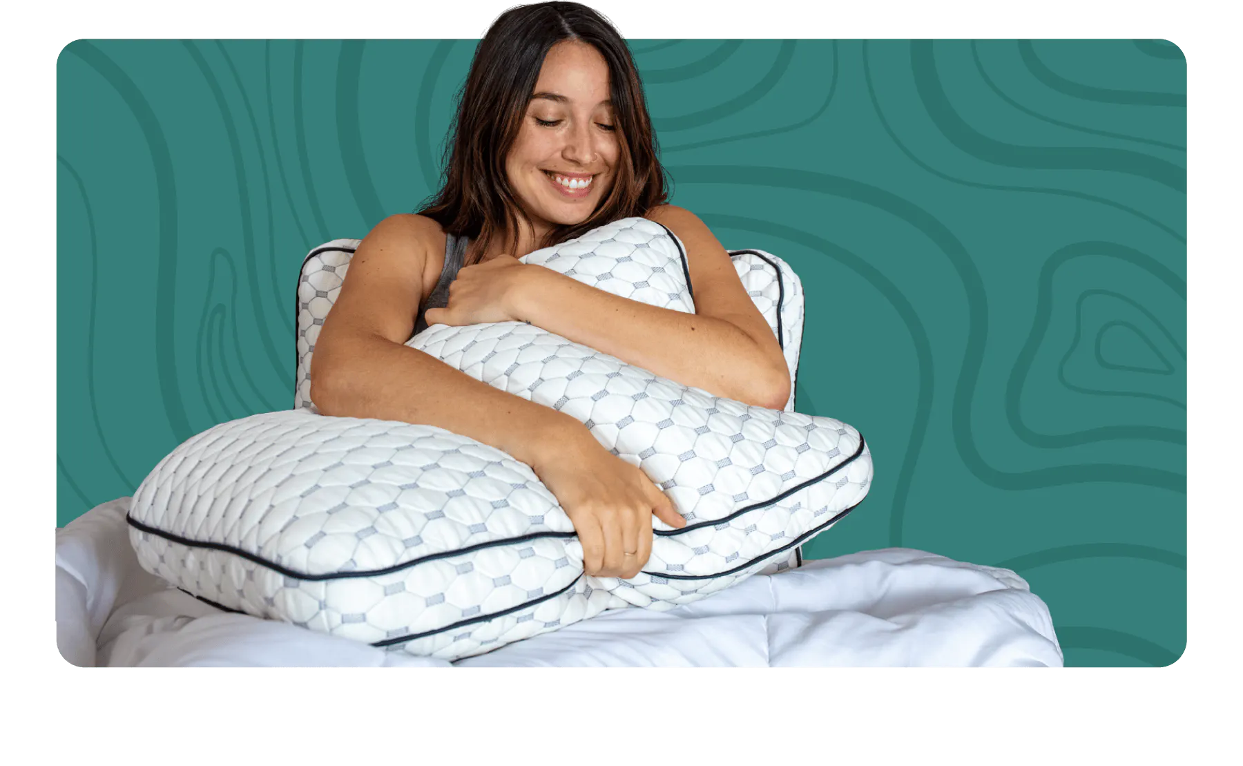 A woman hugging to thick white pillows with dark gray piping and a light gray rectangular pattern
