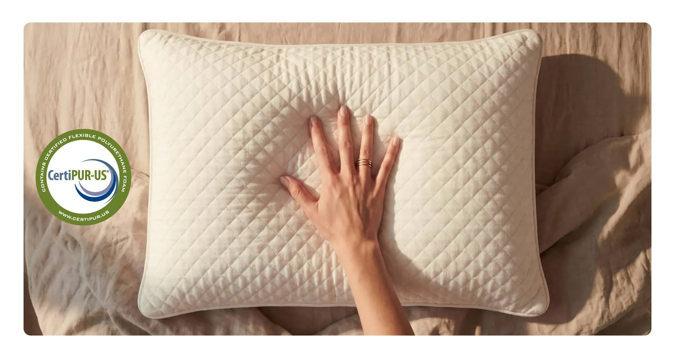 A hand pressing into a pillow to show the responsive nature of the memory foam blend.