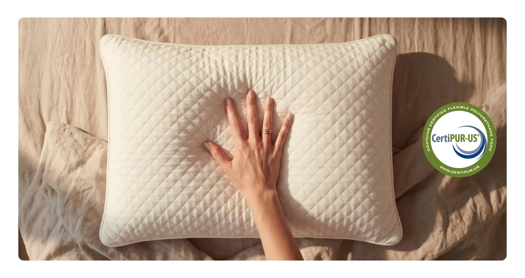 A hand pressing into a pillow to show the responsive nature of the memory foam blend.